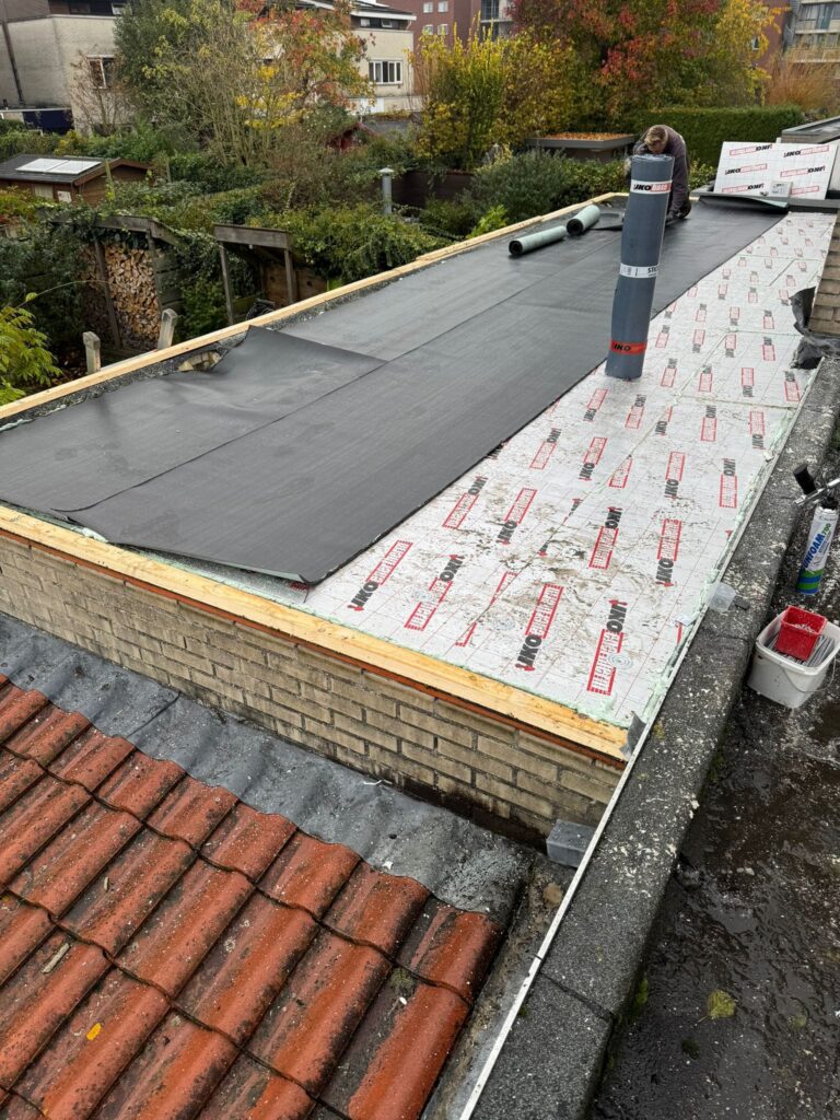 Dakisolatie met afschotisolatie en 2-laags bitumen dakbedekking tijdens een dakrenovatie in Harderwijk, afgewerkt met zinken dakranden.