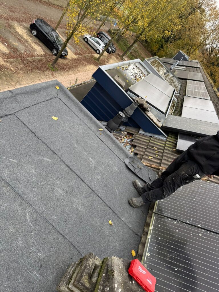 Twee dakkapellen met nieuwe bitumen dakbedekking, zinken dakranden en teruggeplaatste zonnepanelen tijdens een dakrenovatie in Amersfoort.