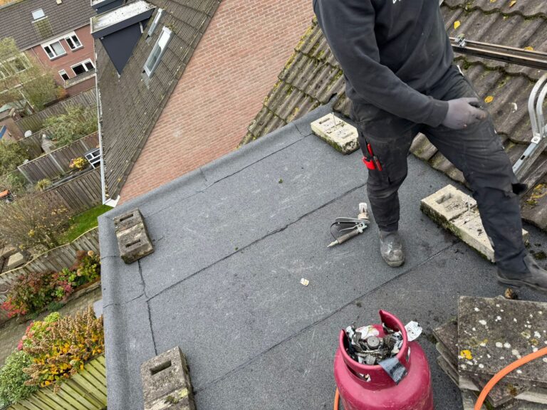 Twee dakkapellen met nieuwe bitumen dakbedekking, zinken dakranden en teruggeplaatste zonnepanelen tijdens een dakrenovatie in Amersfoort.